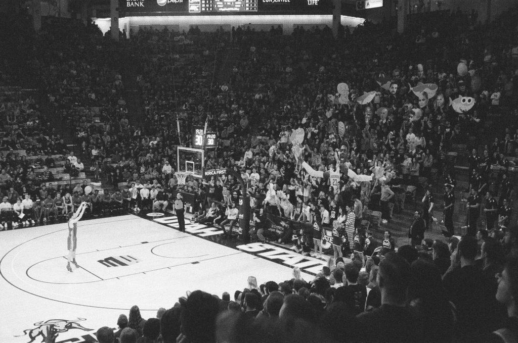 Utah State University's student section distracts an opposing player's free throw with signs and loud noises. Indoor photo at the Spectrum Basketball Stadium with a Rollei 35 camera.