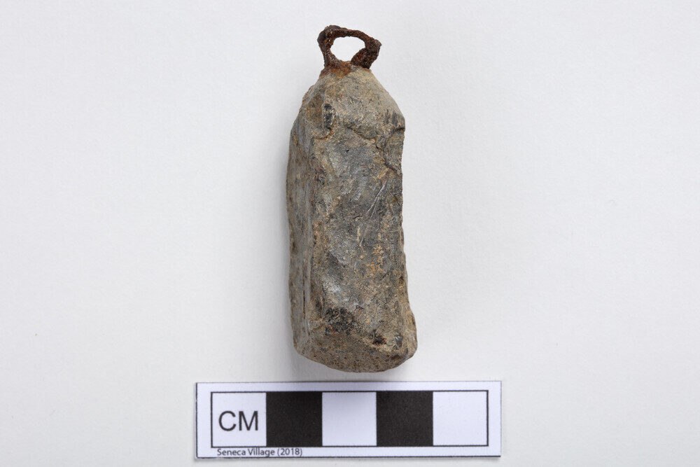 A photo of an oblong and unevenly shaped weight made from lead.