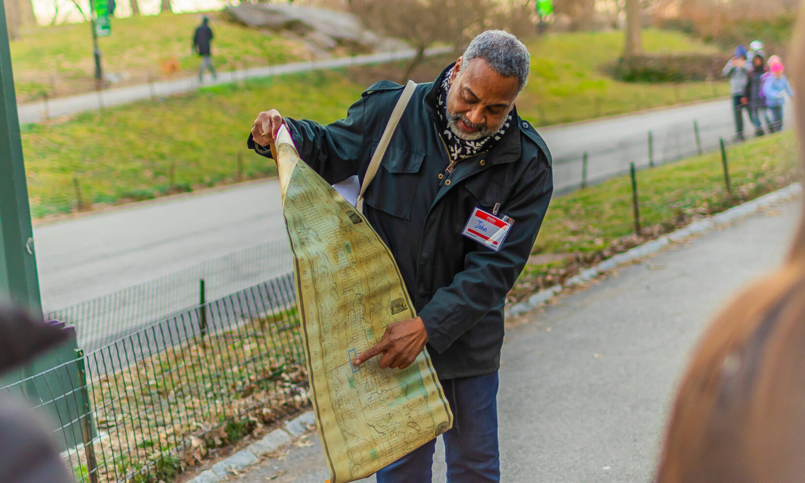 A Central Park Conservancy guide holds a map at Seneca Village in Central Park, NYC
