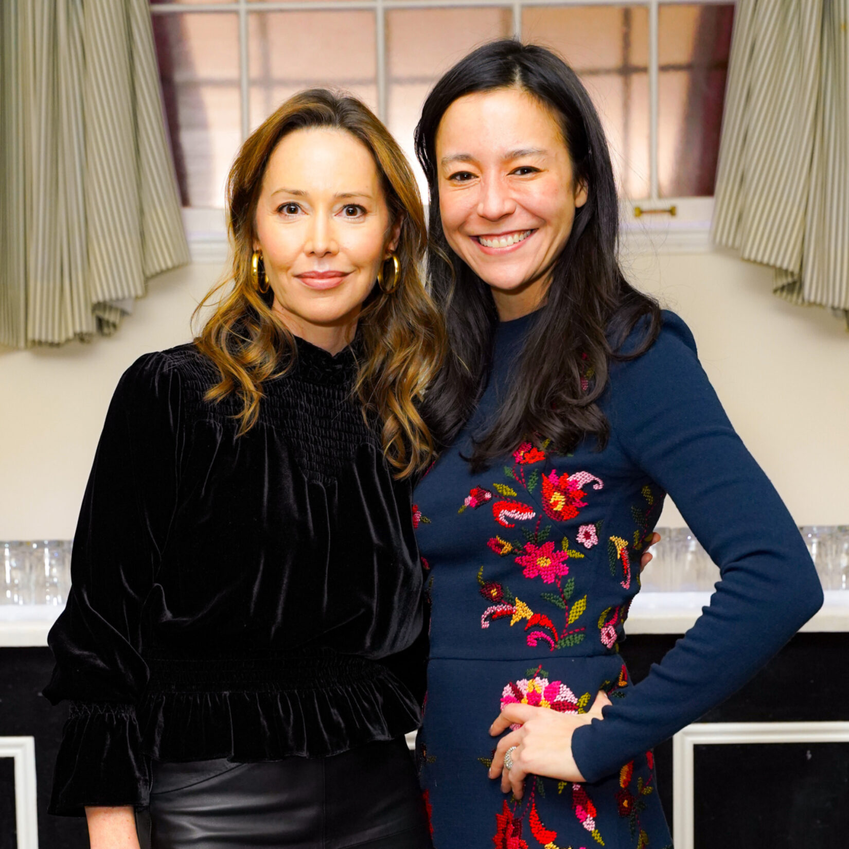 Two women pose and smile